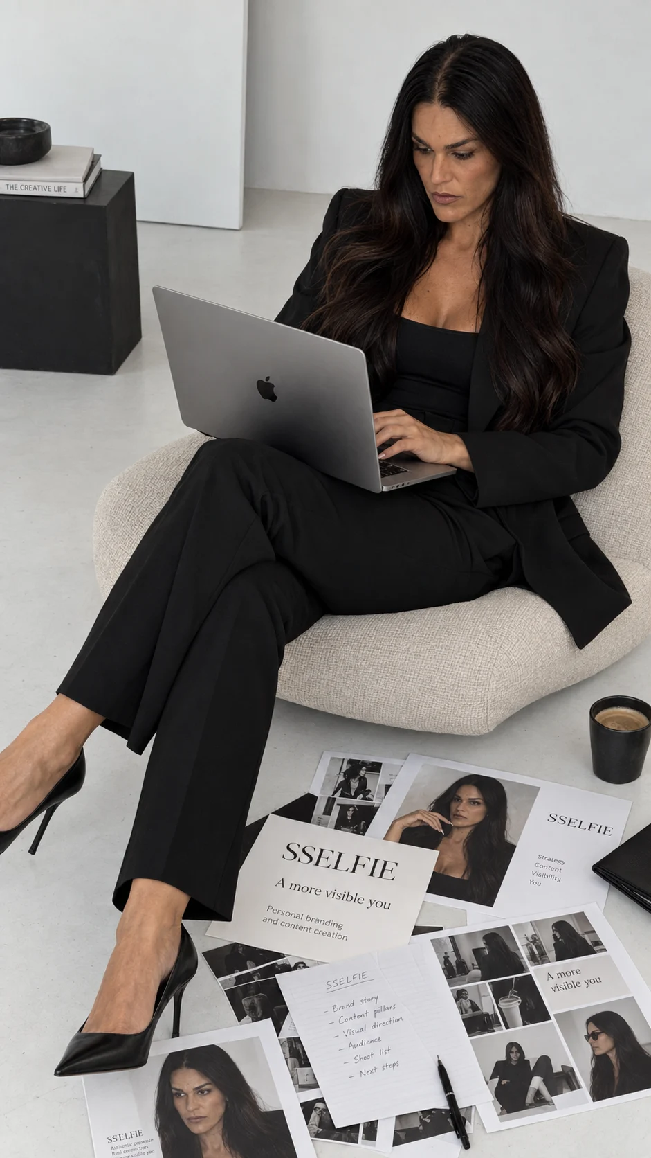 Sandra working on her laptop beside printed SSELFIE photos