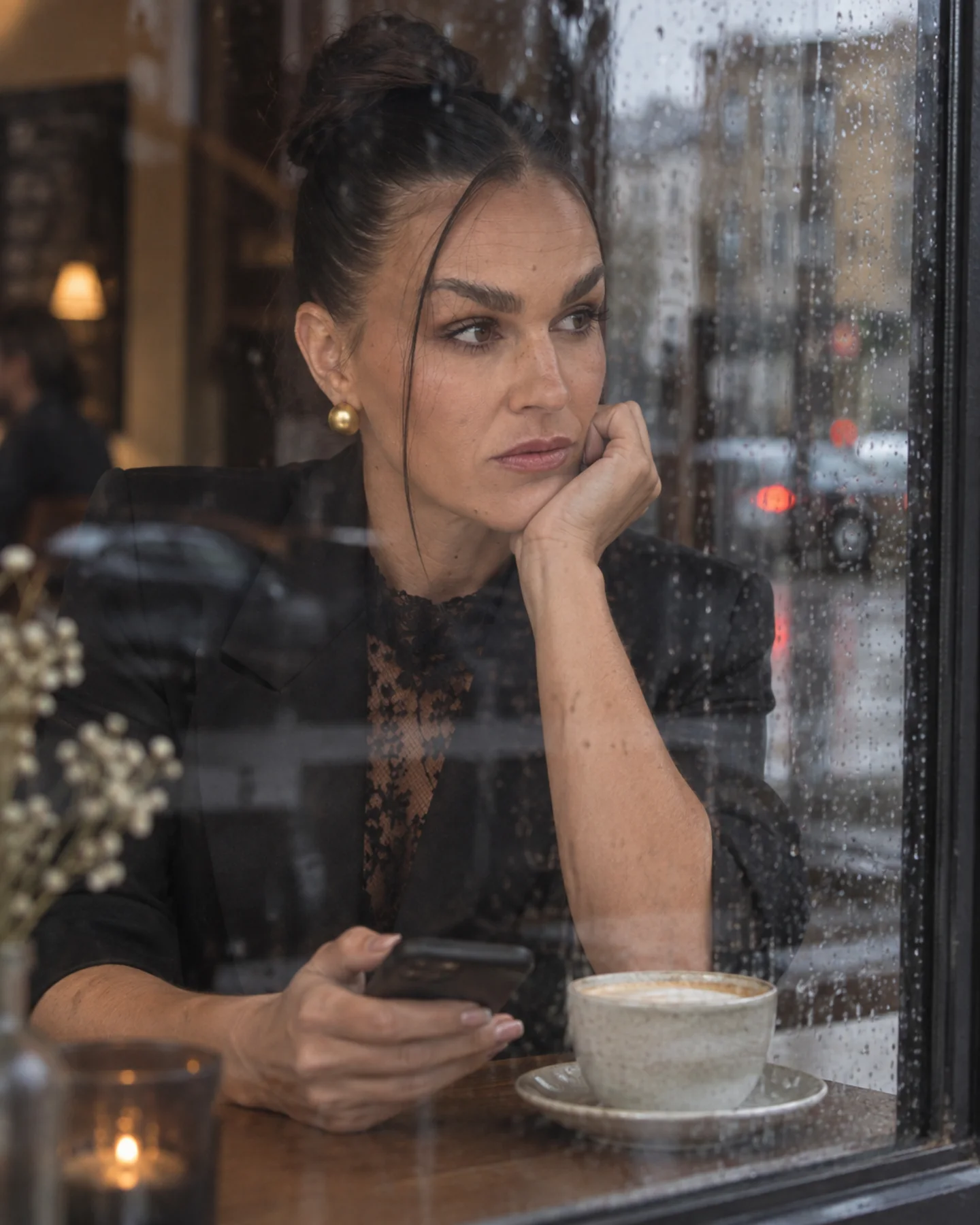 Sandra sitting by a rainy café window